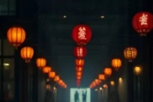 夜色中的影院外景，暖色灯箱映在湿润路面上